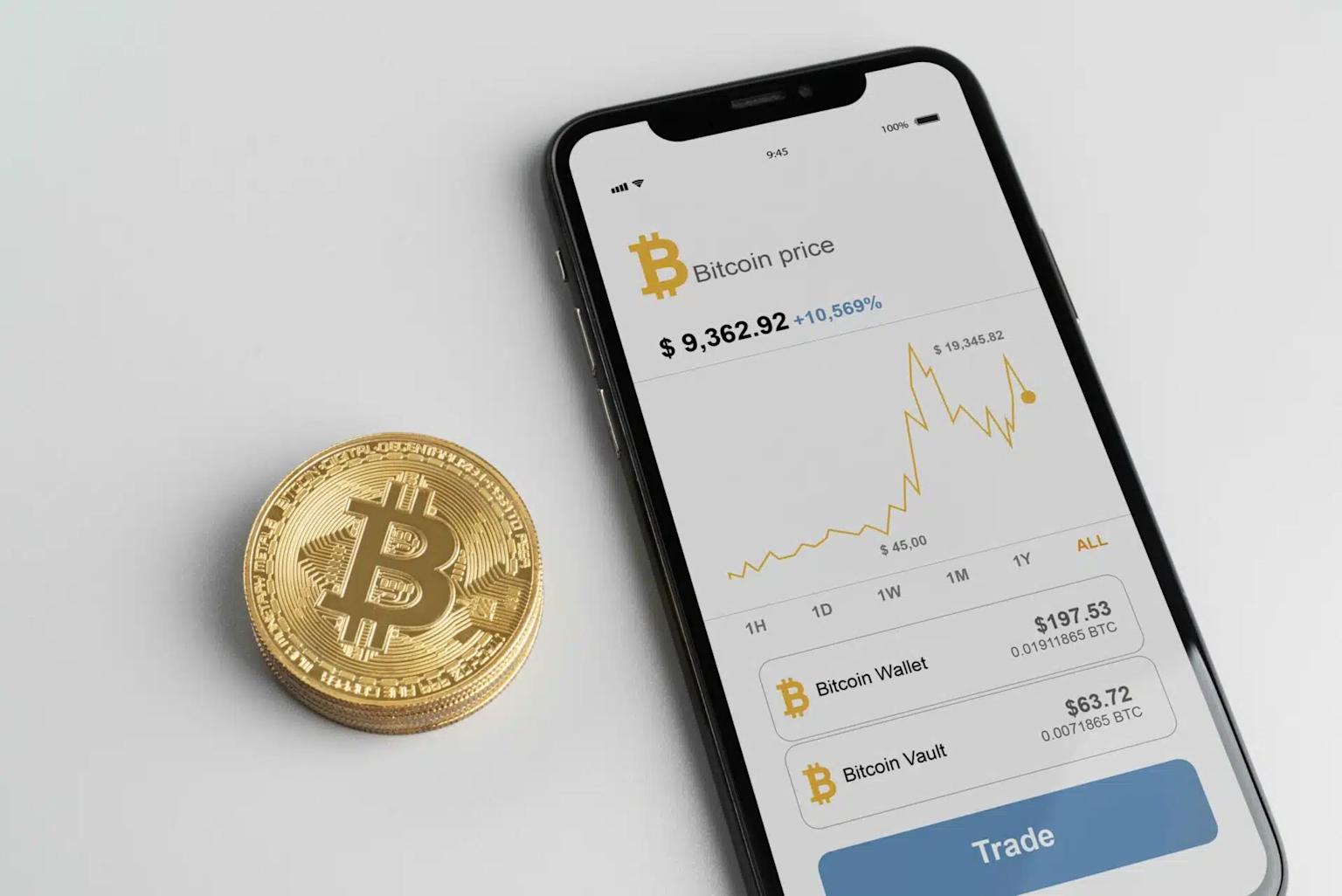 A smartphone app displaying Bitcoin price and trading options alongside physical Bitcoin coins